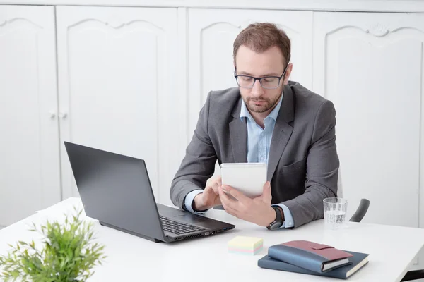Молодой профессионал, работающий над цифровым планшетом за столом в офисе — стоковое фото