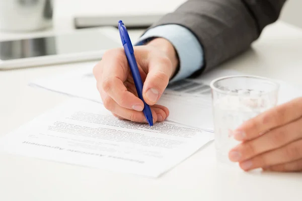 Geschäftsmann füllt Geschäftsdokument per Hand aus — Stockfoto