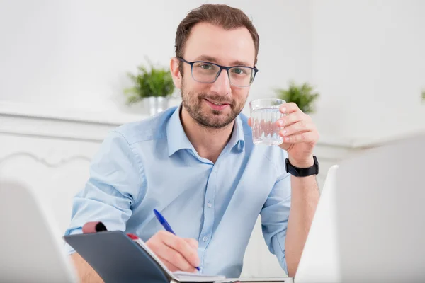 Retrato de un hombre sosteniendo un vaso de agua en el escritorio de la oficina — Foto de Stock