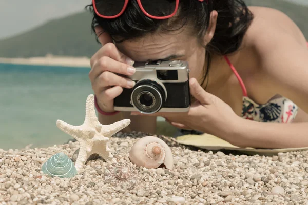 Mujer tomando una foto de accesorios de verano en la playa — Foto de Stock