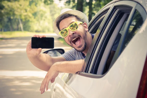 Motorista de carro mostrando smartphone com tela em branco — Fotografia de Stock