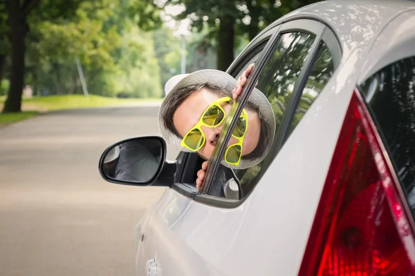 Jeune conducteur jette un coup d'oeil par la fenêtre de la voiture — Photo