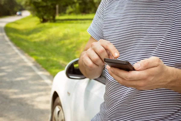 Homem usando smartphone ao lado do carro — Fotografia de Stock