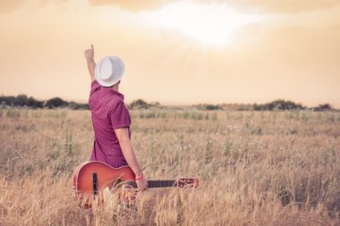 Güneşin tadını akustik gitar ile genç adam 