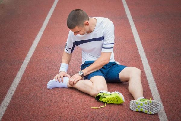 Jogger verificando se seu tornozelo está quebrado ou torcido — Fotografia de Stock