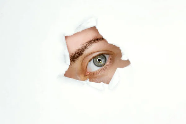 Blue eyed girl looking through ripped paper Template for eye care products design.