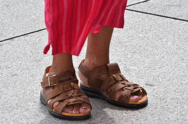 Zaman akışını gösteren parmak arası terlik giymiş bir kadının ayakları.