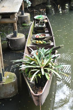 Nehrin ortasında çalılarla süslenmiş bir tekne.