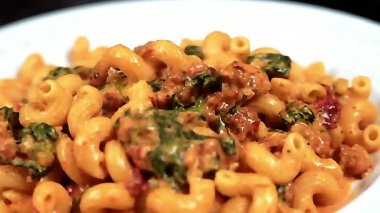 Cavatappi makarnası kremalı sosta pişti ve İtalyan usulü sunumla sıcak servis edildi. Restoran menüleri, makarna promosyonları, yemek pazarlama, yemek servisi görselleri ve gurme makarna yemekleri gösteren ticari stok görüntüleri için idealdir..