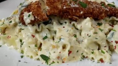 Kremalı beyaz soslu ve yumuşak tavuklu klasik tavuk alfredo makarnası. Bol dokulu sıcak servis ediliyor. Restoran menüleri, İtalyan yemek görselleri, yemek servisi içeriği ve makarna yemeklerinin yer aldığı ticari stok görüntüleri için ideal..