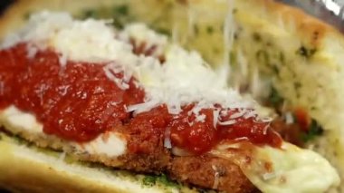 Kızarmış ekmeğin içinde kızarmış tavuk, bol sos ve peynir içeren parmesanlı tavuk sandviçi. Kafe menüleri için ideal, fast food promosyonları, sıradan yemek görselleri, ve ticari stok görüntülü sandviçler..