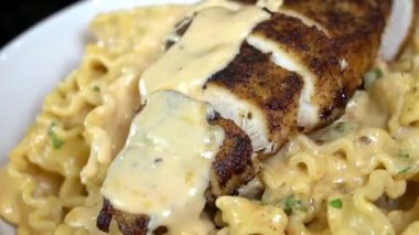 Yumuşak tavuk ve zengin sosla hazırlanmış kremalı tavuk makarnası. Restoran usulü sunumda sıcak servis ediliyor. Makarna menüleri, İtalyan mutfak promosyonları, yemek pazarlama ve makarna tabaklarının sergilendiği ticari stok görüntüleri için ideal..