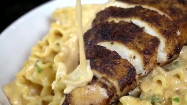 Zengin sos ve yumuşak tavukla pişirilmiş klasik tavuk makarnası, yumuşak dokuda sıcak servis ediliyor. Restoran menüleri, yemek servisi, İtalyan yemek promosyonları ve makarna yemeklerinin yer aldığı ticari stok görüntüleri için uygundur..