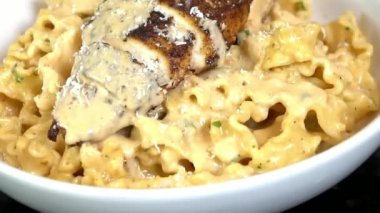 Zengin sos ve yumuşak tavukla pişirilmiş sıcak tavuk makarnası İtalyan restoranı tarzında sunuluyor. Makarna menüleri, konforlu yemek görselleri, yemek promosyonları ve doyurucu makarna yemekleri sunan ticari stok görüntüleri için ideal..