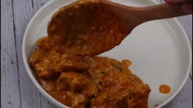 Klasik Hint usulü tavuk tikka masala kremalı domates sosunda pişirilmiş, derin baharat ve aromayla sıcak servis edilmiş. Restoran menüleri, Hint mutfağı promosyonları, yemek servisi görselleri ve köri yemeklerinin sergilendiği ticari stok görüntüleri için ideal..