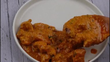 Otantik Hint baharatları ve yumuşak tavukla hazırlanmış kremalı tavuk tikka masala zengin bir sunumla sıcak servis ediliyor. Hint mutfağı menüleri, kültürel gıda görselleri ve köri yemeklerini vurgulayan ticari stok görüntüleri için ideal..