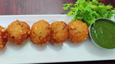 Kızarmış altın sarısı sabudana vada kızarana kadar pişirilir, geleneksel Hint sunumuyla sıcak servis edilir. Hint mutfağı menüleri, oruç tutanlar, abur cubur görselleri ve geleneksel yemekleri vurgulayan ticari stok görüntüleri için uygundur..