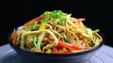 Yumurtalı erişteler yumurta ve baharatla kızartılmış, Hint usulü sıcak servis ediliyor. Restoran menüleri, sokak yemekleri, Asya mutfağı promosyonları ve erişte tabakları sergilenen ticari stok görüntüleri için ideal..