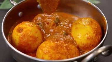 Bol soslu haşlanmış yumurtalarla hazırlanmış baharatlı yumurta, rahatlatıcı bir yemek kadar sıcak servis edilir. Hint mutfağı menüleri, ev yapımı yemek görselleri, restoran promosyonları ve yumurta bazlı köri sergilenen ticari stok görüntüleri için ideal..