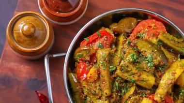 Patlıcan ve patates sabzi baharatla pişirilir ve geleneksel Hint sebze yemeği olarak servis edilir. Vejetaryen menüler, Hint ev usulü yemek pişirme görselleri, restoran promosyonları ve Sabzi yemeklerinin sergilendiği ticari stok görüntüleri için ideal..