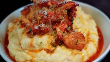 Sarımsaklı tereyağlı ıstakoz kremalı patates püresi ile sıcak servis edilir ve birinci sınıf deniz ürünleri olarak sunulur. Lüks yemek menüleri, güzel restoran görselleri, gurme yemek promosyonları ve ıstakoz yemekleri gösteren ticari stok görüntüleri için ideal..