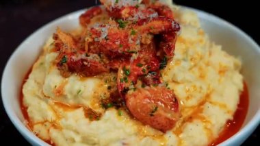 Sarımsaklı tereyağlı ıstakoz sulu ve yumuşak olana kadar pişirilir, özel deniz ürünleri yemeği olarak kremalı patates püresi ile servis edilir. Lüks yemek menüleri ve güzel restoran görselleri için ideal.