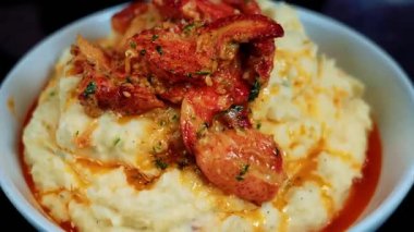 Pürüzsüz patates püresiyle eşleştirilmiş kaliteli sarımsaklı ıstakoz, zarif bir sunumla sıcak servis ediliyor. Güzel yemek menüleri, lüks yemek görselleri, deniz ürünleri promosyonları ve gurme ıstakoz yemeklerini vurgulayan ticari stok görüntüleri için mükemmel..