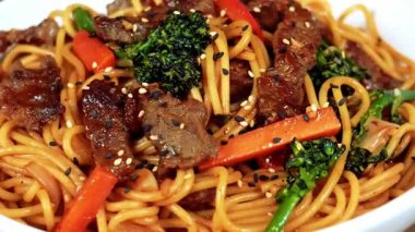 Erişte ve baharatlı sarımsaklı taze sığır eti dilimleri içeren sulu sarımsaklı şehriye, bol aromalı sıcak servis edilir. Restoran menüleri, yemek teslimatı görüntüleri ve ticari stok görüntüleri için uygun..