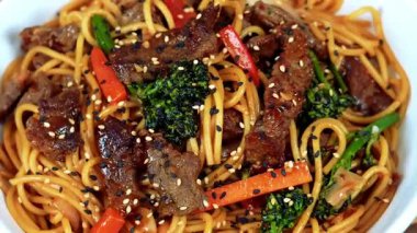 Lezzetli biftek ve erişteyle pişirilmiş klasik sarımsaklı erişte. Dengeli baharatlı sıcak servis ediliyor. Restoran menüleri, füzyon mutfak promosyonları ve şehriye yemeklerini vurgulayan ticari stok görüntüleri için ideal..