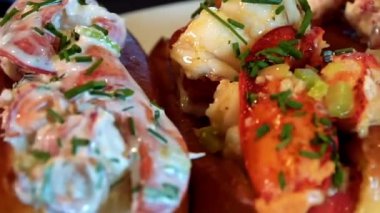 Istakozlu sandviç. Istakoz eti ile dolu. Taze deniz ürünleri sandviçi olarak servis ediliyor. Sahil mutfağı menüleri, deniz ürünleri restoranları ve ıstakoz sandviçi sergilenen ticari stok görüntüleri için ideal..