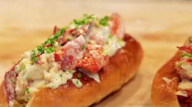 Zengin ıstakoz dolması ve yumuşak ekmekle hazırlanmış kaliteli ıstakoz sandviçi. Zarif bir sunumla taze servis ediliyor. Gurme menüler, deniz ürünleri promosyonları ve ıstakoz yemeklerini vurgulayan ticari stok görüntüleri için ideal..