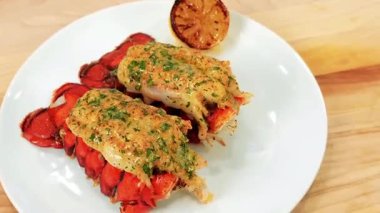 Taze ıstakoz kuyruğu birinci sınıf bir deniz ürünleri tabağı olarak sunulur, taze et ve doğal doku sergilenir. Deniz ürünleri pazarları, lüks yemek görselleri, gurme yemek promosyonları ve ıstakoz sunumunu ön plana çıkaran ticari stok görüntüleri için ideal..