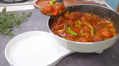 Baharatlı sosa karıştırılmış kızarmış sebze toplarıyla hazırlanmış klasik sebze mançuryası. Sıcak servis ediliyor. Hint-Çin mutfağı görüntüleri, restoran menüleri ve füzyon yiyeceklerini gösteren ticari stok görüntüleri için ideal..