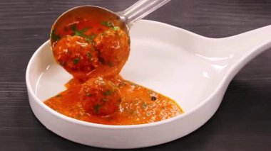 Zengin Hint sosunda pişirilen ve doyurucu bir konfor yemeği olarak sunulan klasik köfteli kofta körisi. Restoran menüleri, ev yapımı yemek görselleri ve köri tabakları sergilenen ticari stok görüntüleri için ideal..