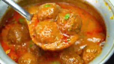 Zengin kofta köfteli köri aromatik baharatlar ve kalın sosla hazırlanmış, derin aromalı sıcak servis edilmiş. Hint mutfağı promosyonları, restoran menüleri ve ticari stok görüntüleri için ideal..