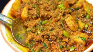 Baharat ve sosla pişirilmiş kıyma ve patates körisi. Rahatlatıcı bir Hint yemeği gibi sıcak servis ediliyor. Restoran menüleri, geleneksel mutfak görüntüleri ve et körisinin sergilendiği ticari stok görüntüleri için ideal..