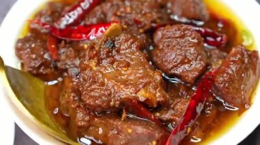 Kalın baharatlarla ve kalın sosla hazırlanmış zengin koyun eti Hint yemeği gibi sıcak servis edilir. Restoran menüleri ve kültürel gıda görselleri için uygun.