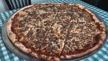 Büyük mantarlı pizza, mükemmel pişmiş, bol aromalı sıcak servis ediliyor. Pizza menüleri, sıradan yemek görselleri ve ticari stok görüntüleri için ideal..