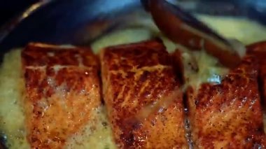 Gurme tereyağlı haşlanmış tavada kızartılmış somon balığı restoran tarzına zengin bir lezzet ve pürüzsüz bir doku sundu. Lüks yemek ve deniz ürünleri stoku görüntüleri için ideal..