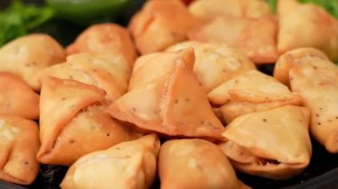 Baharatlı patatesle dolu gevrek aloo samosa popüler bir Hint sokak yemeği olarak servis edilir. Atıştırmalık menüler, festival yemekleri ve ticari stok görüntüleri için ideal..