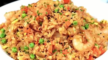 Yumuşak karides ve baharatlı pirinçle pişirilmiş karidesli pilav, öğlen veya akşam yemeği menülerinde ve ticari yemek görsellerinde restoranda sıcak servis ediliyor..