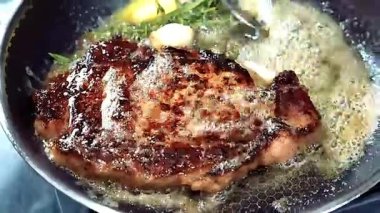 Tavada kurutulmuş biftek, usulca tereyağlı ve sulu mükemmel pişirilmiş, restoran stili, kaliteli bir et yemeği olarak sunuluyor. Güzel yemek görselleri için ideal..