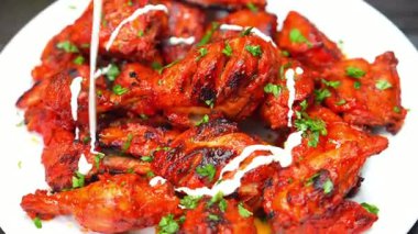 Yoğurt ve baharatla marine edilmiş dumanlı tandır tavuğu. Yumuşak ve lezzetli olana kadar ızgara. Menüler ve ticari yemek görselleri için ideal..