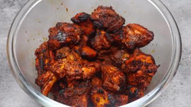 Acılı tandır tavuklu tikka şiş dumanlı ve yumuşak olana kadar ızgara, Hint aperatifi olarak sıcak servis edilir..