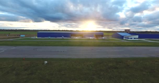 Petits avions près du hangar au coucher du soleil — Video