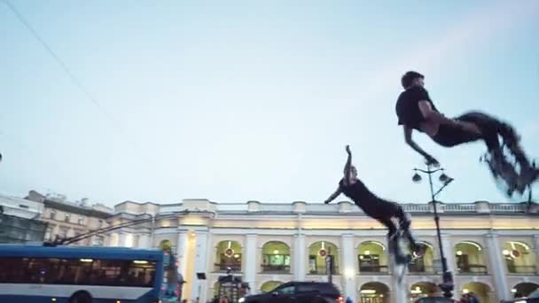 Чоловіки стрибати через голову на вулиці міста — стокове відео