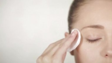 Yüzündeki makyajı temizleyen kadın.