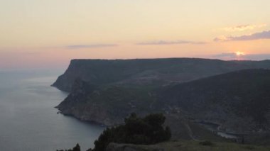 Günbatımı parlak mavi deniz ve tepeler ile