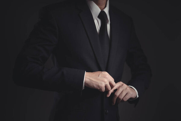 Close up shot of businessman in black suit. Elegant handsome on black background.