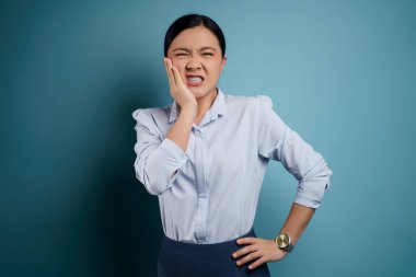 Asyalı kadın hastaydı. Dişi ağrıyordu. Yanağına dokunuyordu..